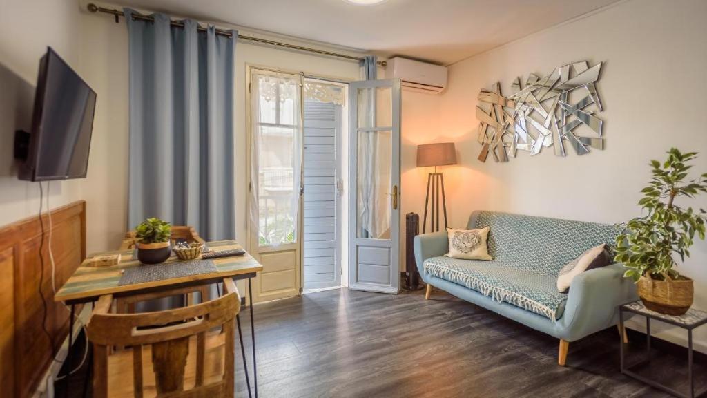 a living room with a blue couch and a tv at 1A - Chambres et Appartements au calme - Centre St Denis - Barachois in Saint-Denis