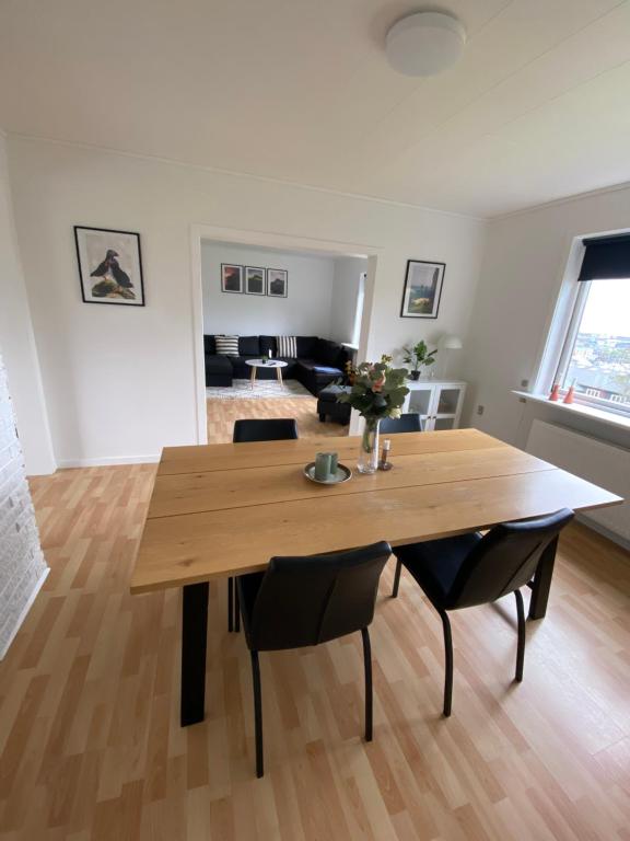 una mesa de madera y sillas en la sala de estar. en Apartment in the center of Tórshavn, free parking. en Tórshavn