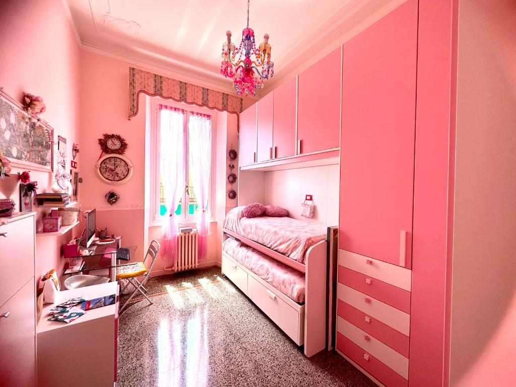 een roze slaapkamer met een bed en een kroonluchter bij Notti magiche a Santa Margherita ligure in Santa Margherita Ligure
