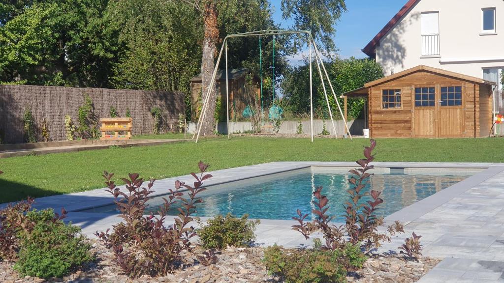 una piscina en un patio con un columpio en La Maison d'Enfance en Heimsbrunn