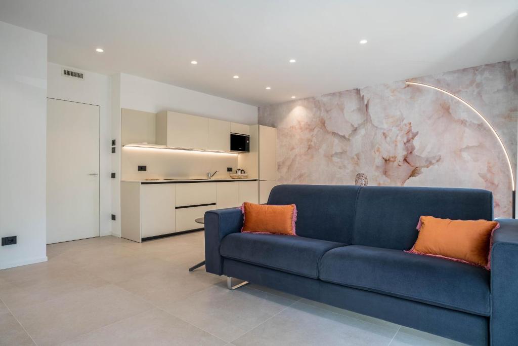 - un canapé bleu dans le salon avec un mur en marbre dans l'établissement Appartamento Midum Family Balcony, à Trente
