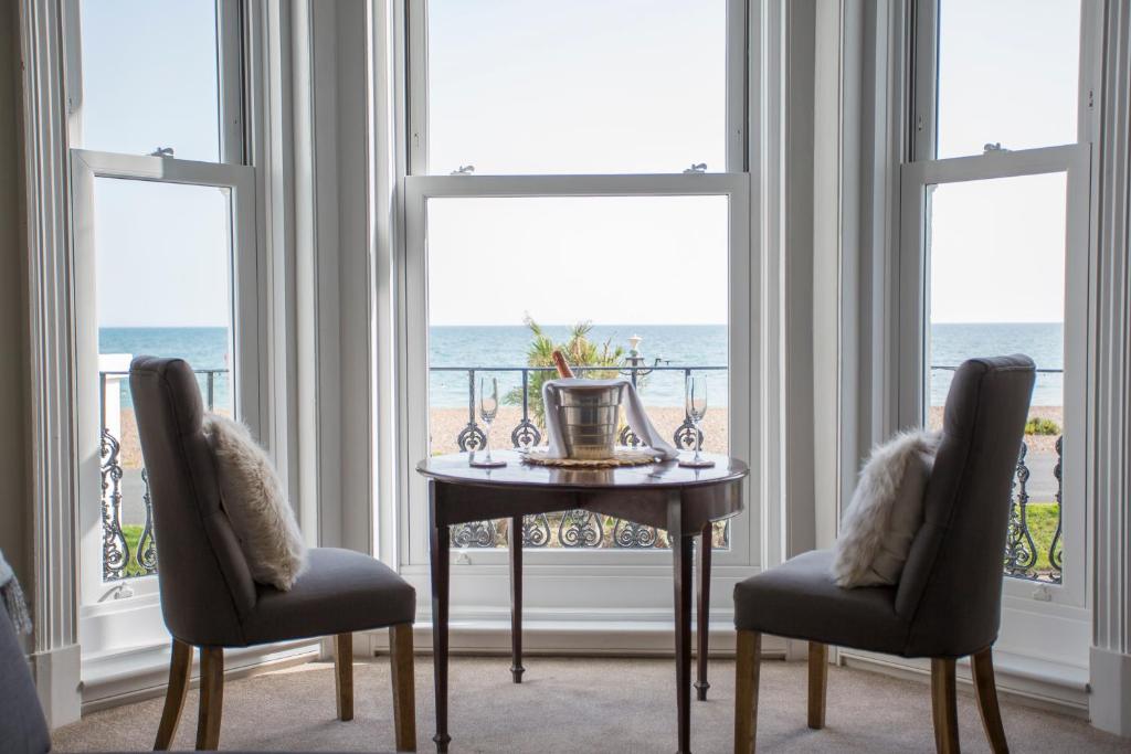 a dining room with a table and two chairs and the ocean at Seaways Apartment in Worthing