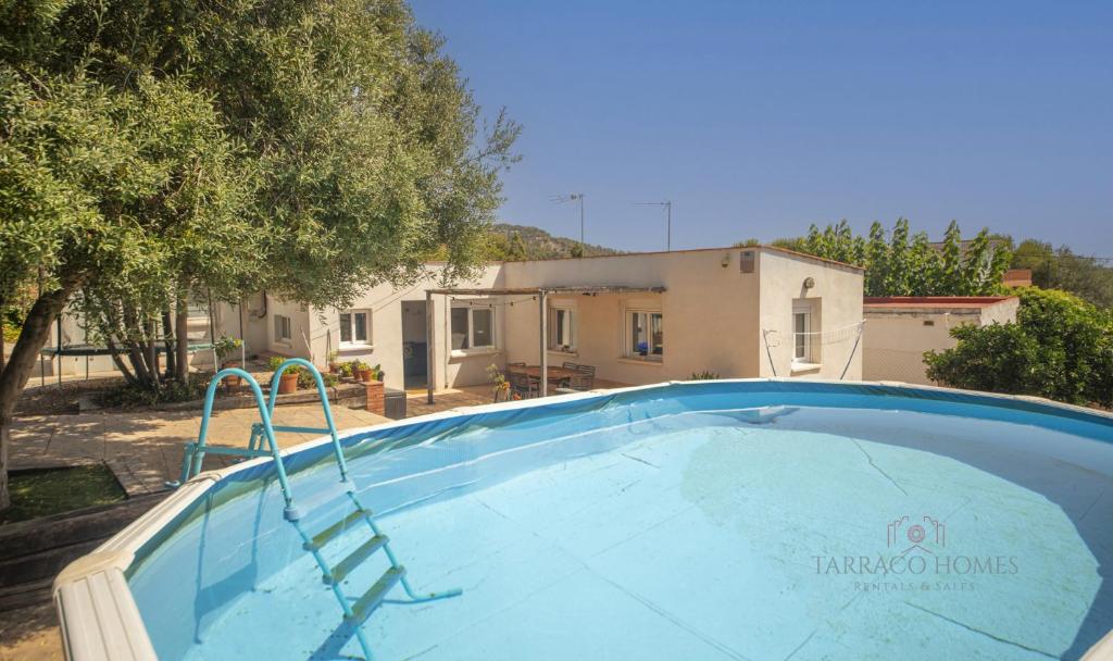 una gran piscina frente a una casa en TH46 Casa con piscina 900 m de la playa Arrebassada en Tarragona