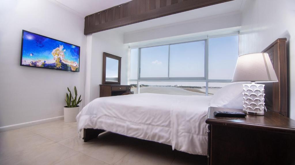 1 dormitorio con cama grande y ventana grande en Suite 206, Riverfront, vista al río, Puerto Santa Ana, Guayaquil, en Guayaquil