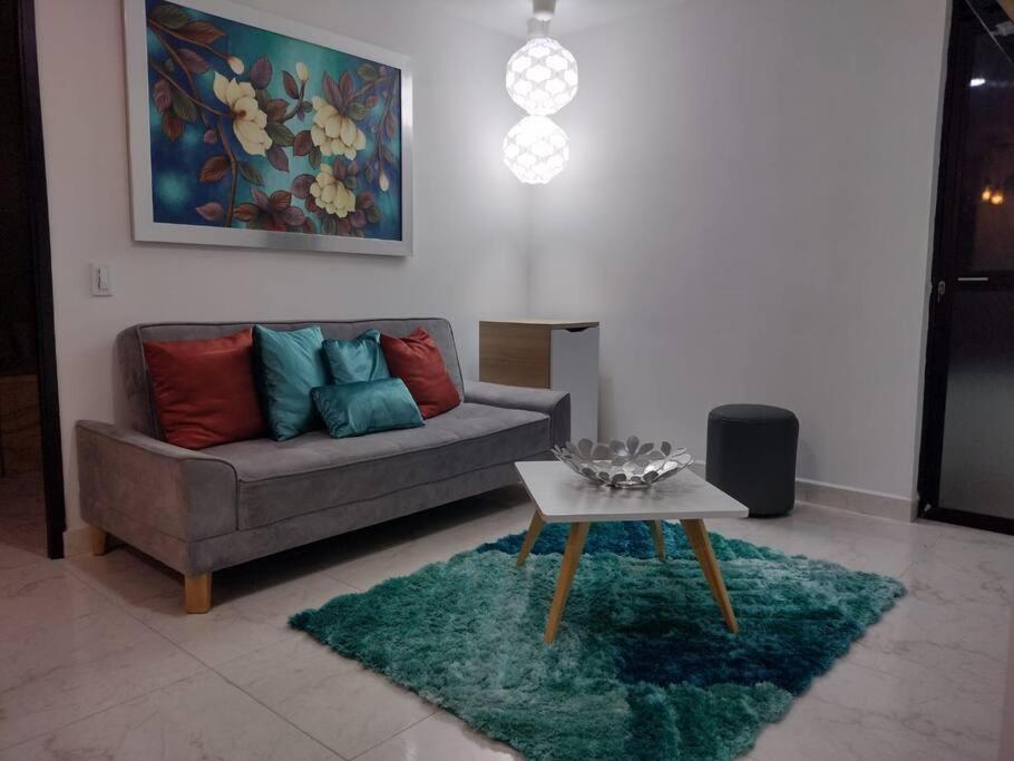 uma sala de estar com um sofá e uma mesa em Lindo Apartamento en Sabaneta em Sabaneta