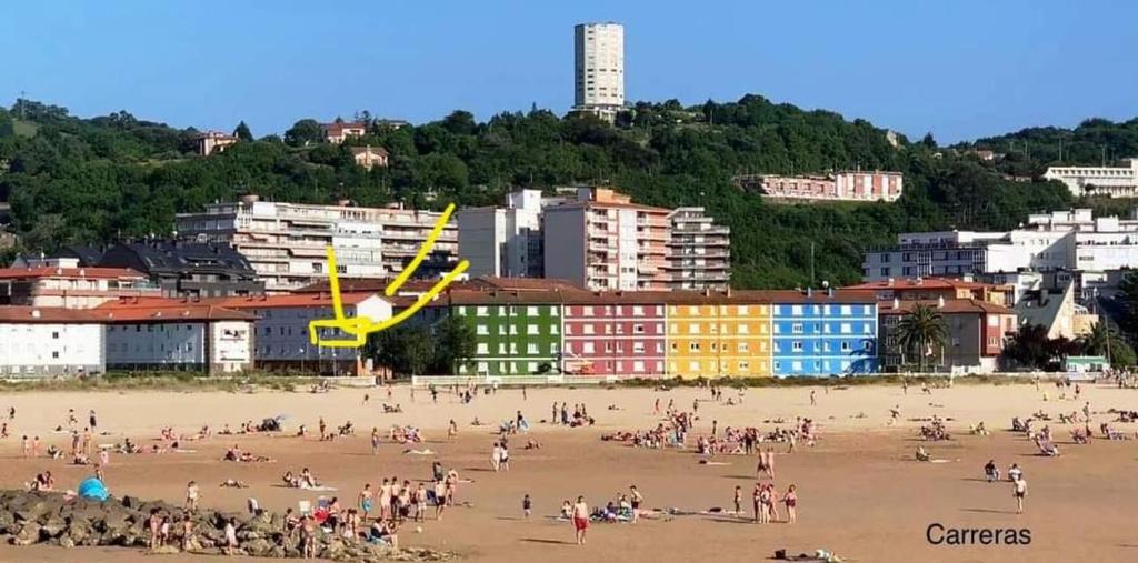 a group of people on a beach with buildings at Apartamento El Muro in Laredo