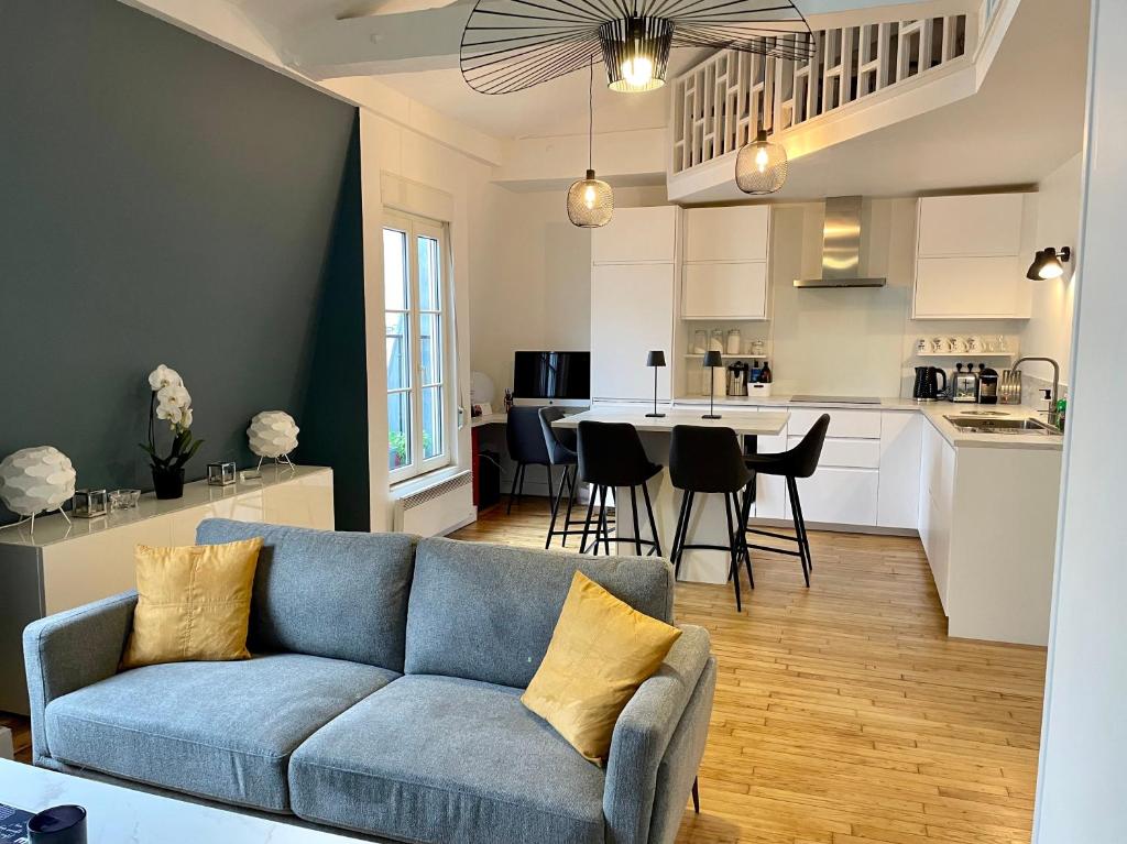 Il comprend un salon et une cuisine avec un canapé bleu. dans l'établissement Le Monceau - Charmant appartement mezzanine Paris, à Paris