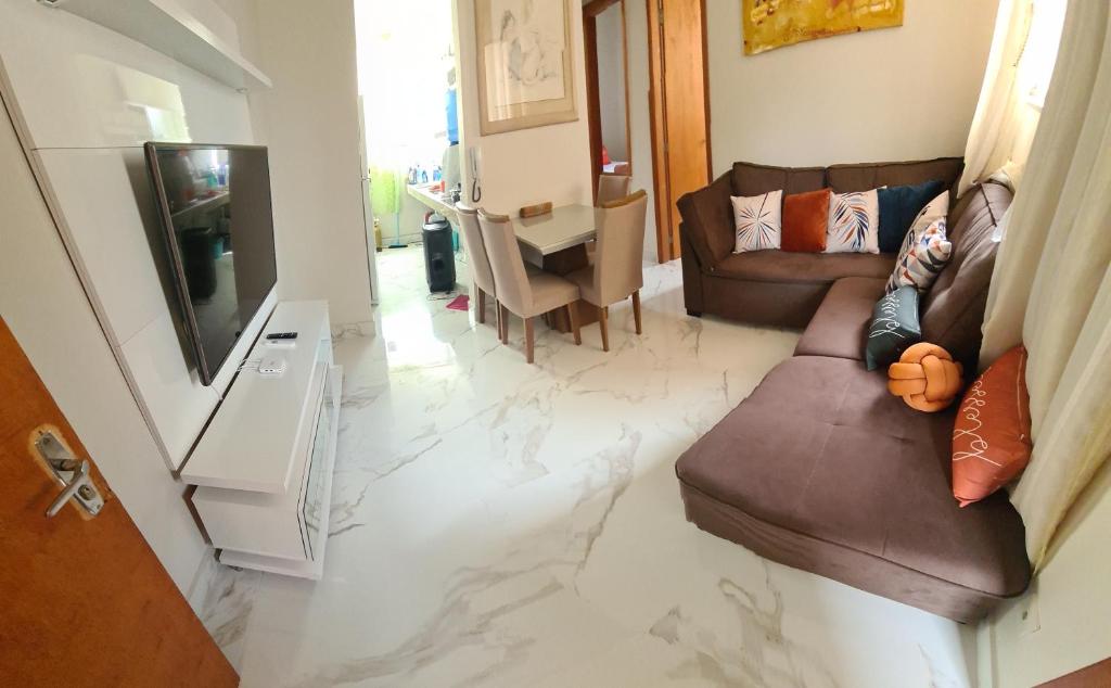 a living room with a couch and a television at Apartamento in Capitólio