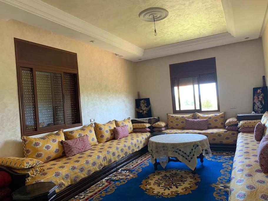 een woonkamer met een bank en een tafel bij villa avec piscine à louer in Bir Jedíd Saint-Hubert