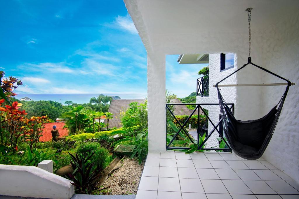 a hammock hanging from the side of a house at Villa Roca Boutique Resort & Suites - ADULT ONLY in Manuel Antonio