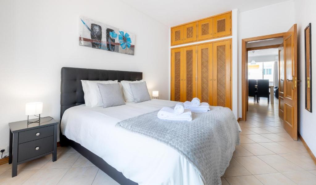a bedroom with a large bed with towels on it at Sea-Front near Vilamoura - with AC, WiFi, Netflix in Quarteira