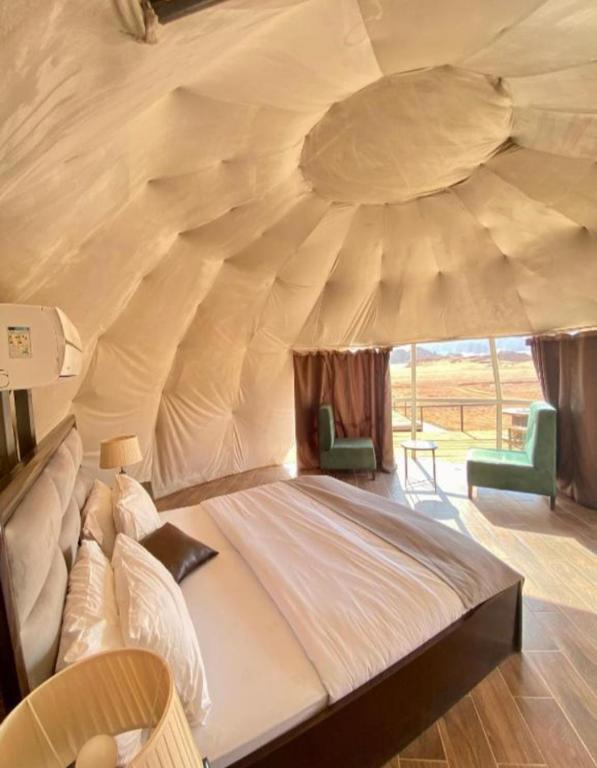 a bedroom with a large bed in a tent at Wadi Rum Calma camp in Aqaba