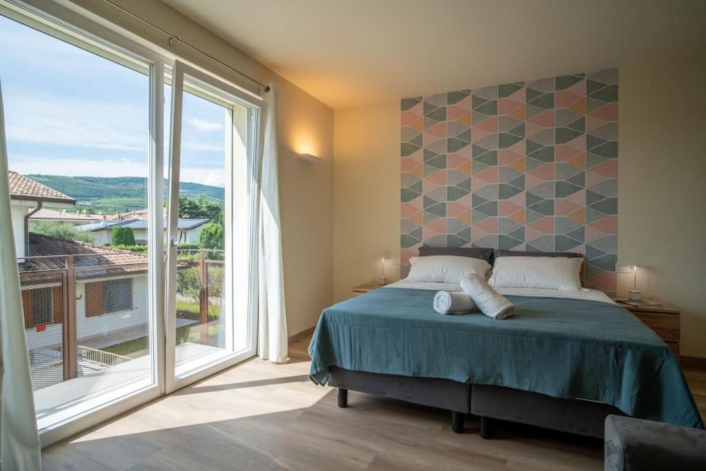 ein Schlafzimmer mit einem Bett und einem großen Fenster in der Unterkunft Monolocale Moderno Valpolicella Verona - Agni in San Pietro in Cariano