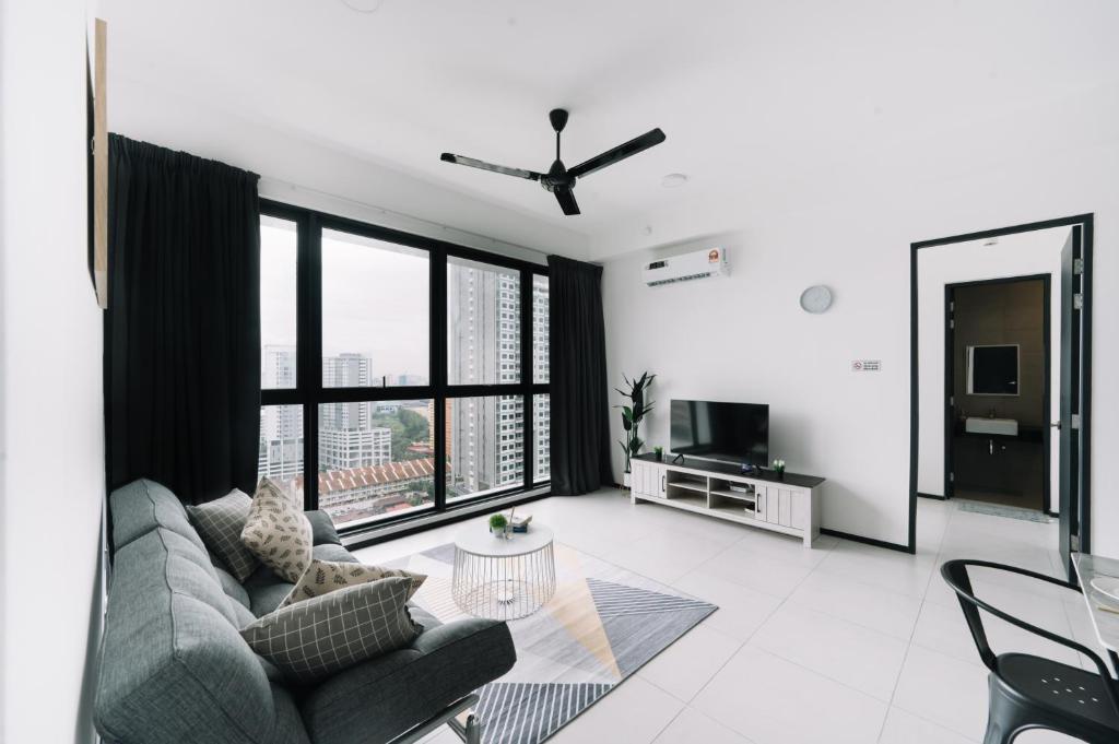 a living room with a couch and a large window at NEW Infinity Pool 3 Bedrooms 2 Carparks in Jelutong