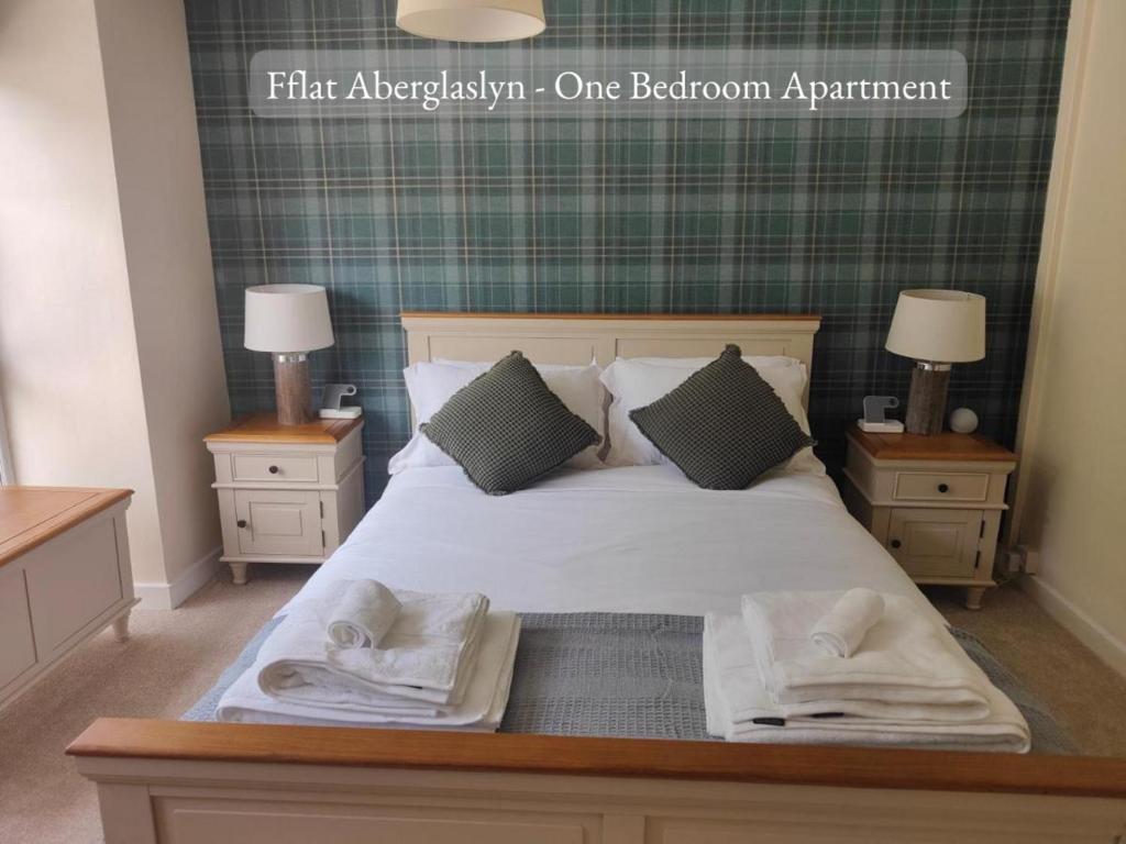 1 dormitorio con 1 cama con 2 mesitas de noche y 2 lámparas en Llew Accommodation - The Townhouse en Beddgelert