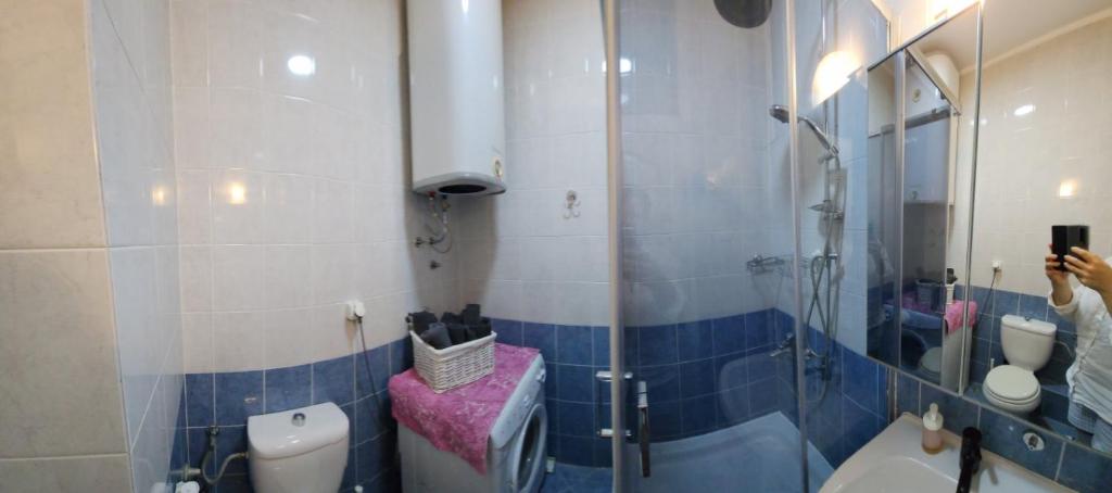 een vrouw die een foto neemt van een badkamer met een douche bij Tesa in Novi Beograd
