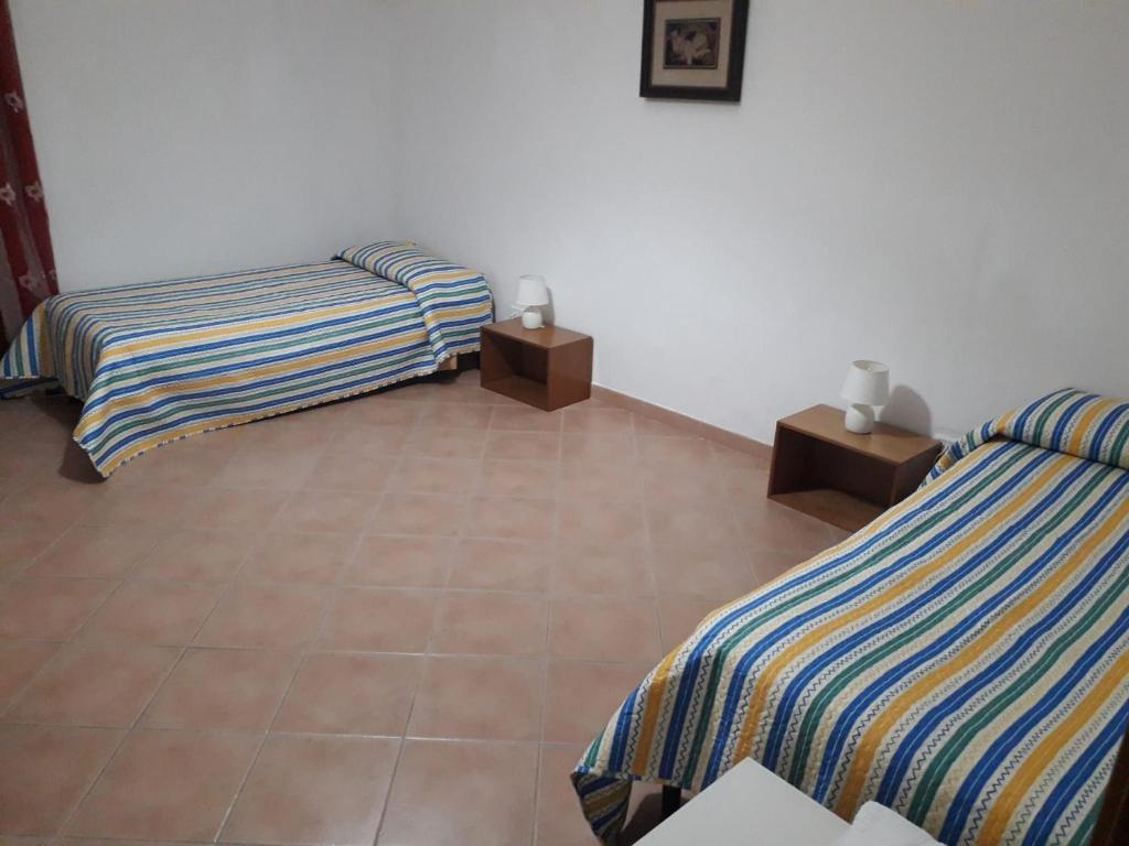 Zimmer mit 2 Betten und 2 Nachttischen in der Unterkunft Casa Annamaria in Milazzo