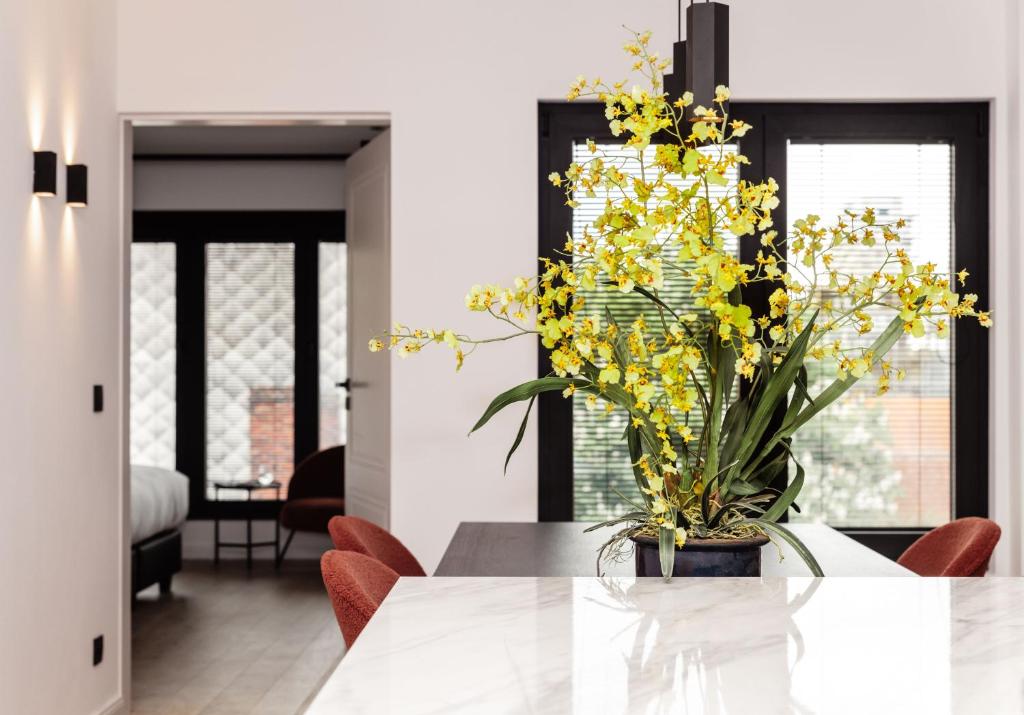 un vaso di fiori gialli seduto su un tavolo di CH Longstay 33 a Courtrai