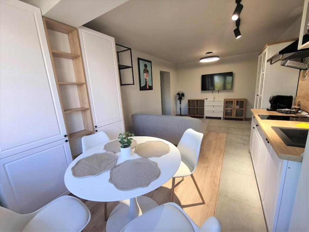 a kitchen with a table and white chairs in a room at Apartament 209 in Alba Iulia
