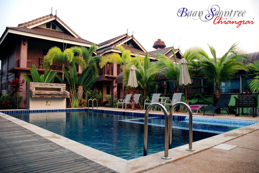 a swimming pool in front of a house at Baan Soontree Resort in Chiang Rai