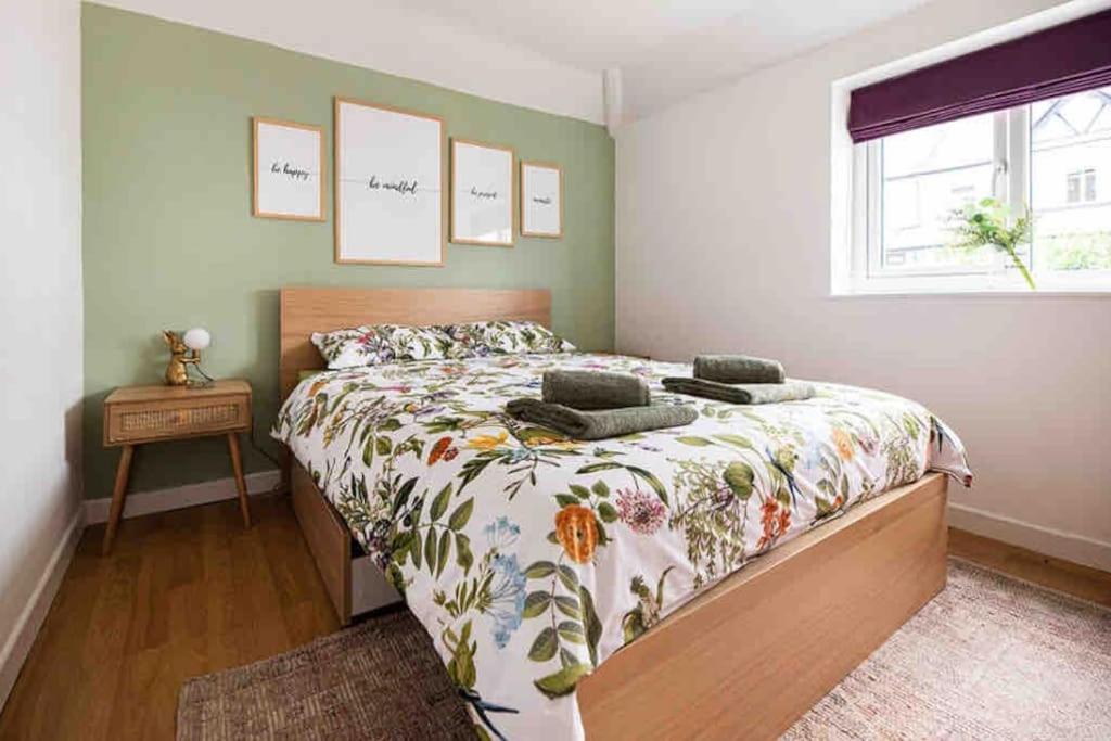 um quarto com uma cama com colcha floral e uma janela em Kingsgate Bay Bungalow - 950meter to Beach Dog friendly em Kent