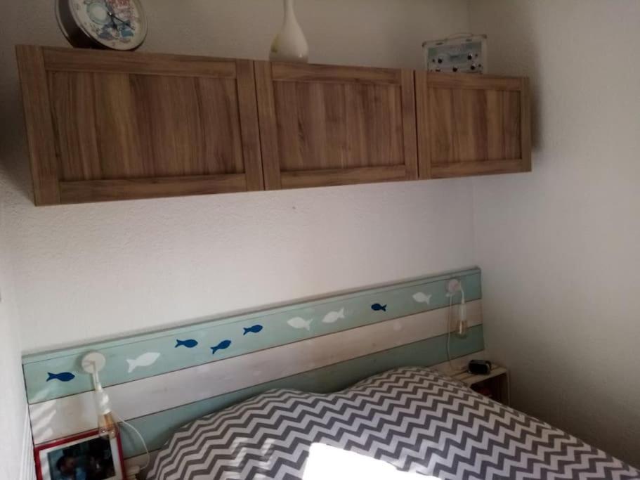 a bedroom with a headboard with birds on the wall at Charmant appartement à Sainte Marie la mer (66470) in Sainte-Marie-Plage