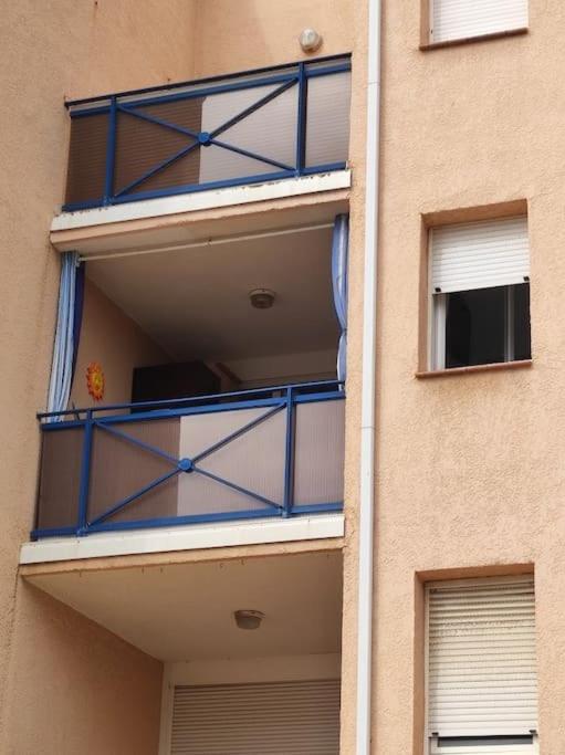 a building with blue balconies on the side of it at Charmant appartement à Sainte Marie la mer (66470) in Sainte-Marie-Plage