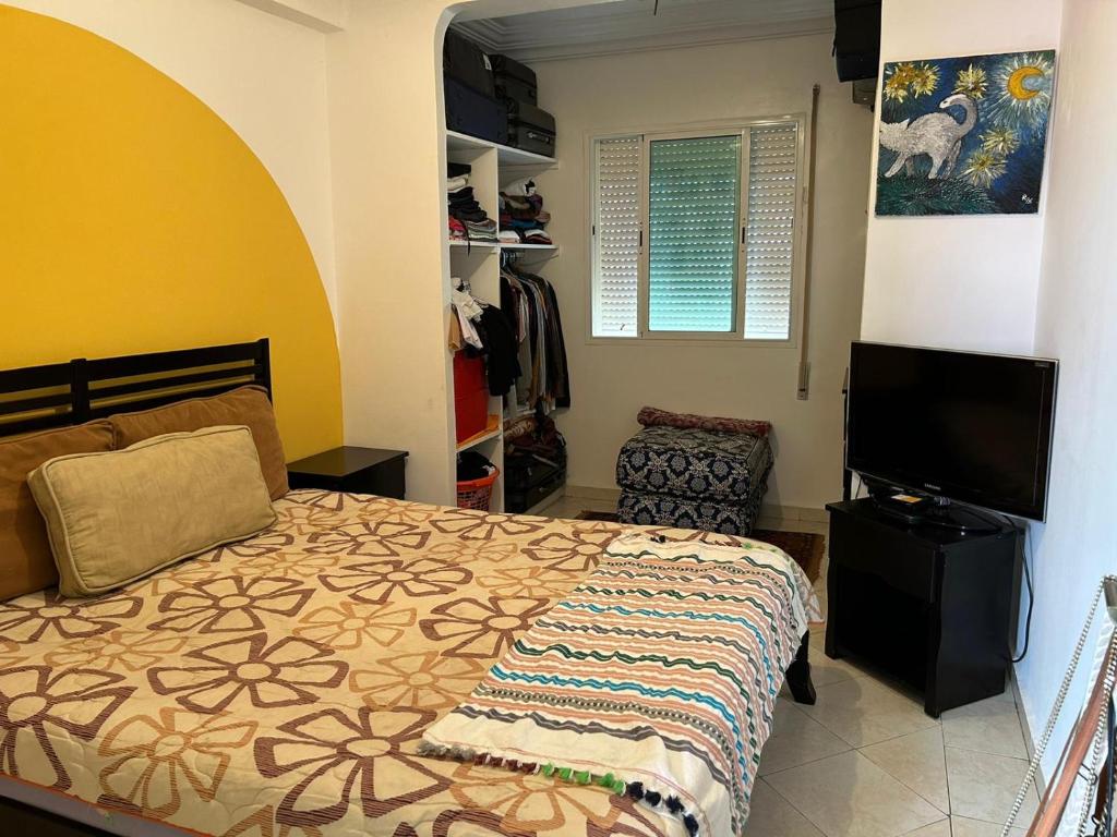 Schlafzimmer mit einem Bett und einem Flachbild-TV in der Unterkunft Apparemment à louer in Azemmour