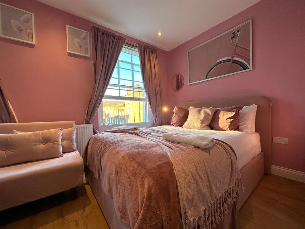 ein Schlafzimmer mit einem Bett, einem Fenster und einem Sofa in der Unterkunft Gloucester Place - Baker Street in London