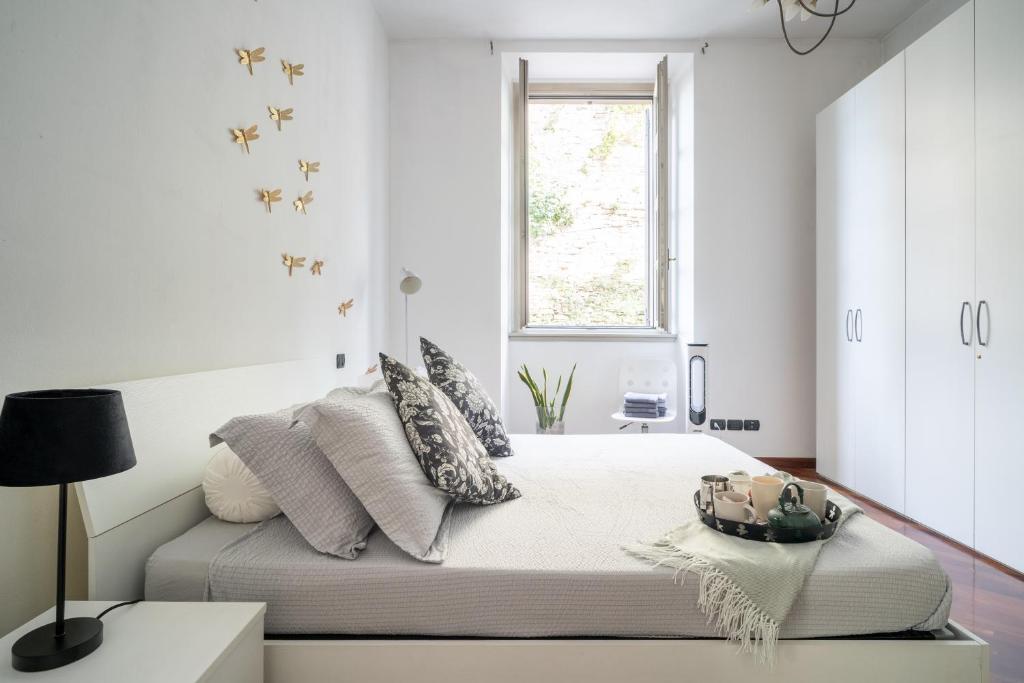 Habitación blanca con cama y ventana en Casa Bea - Art and Prestige, en Bérgamo