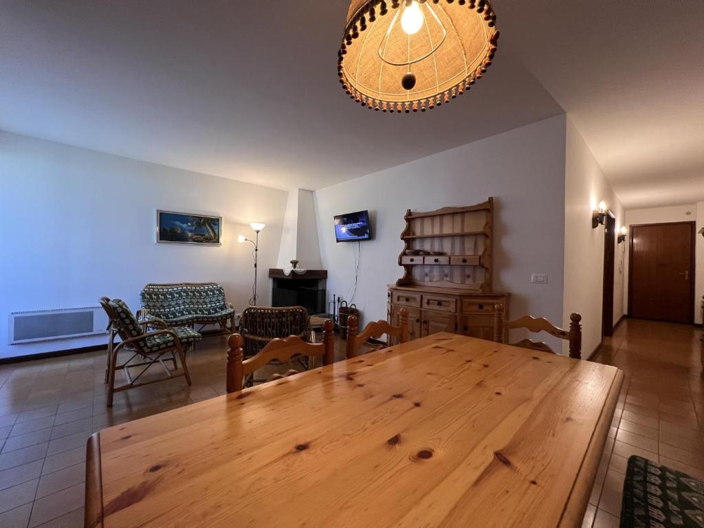 uma sala de jantar com uma mesa de madeira e cadeiras em Trilocale Rendena 035 em Giustino