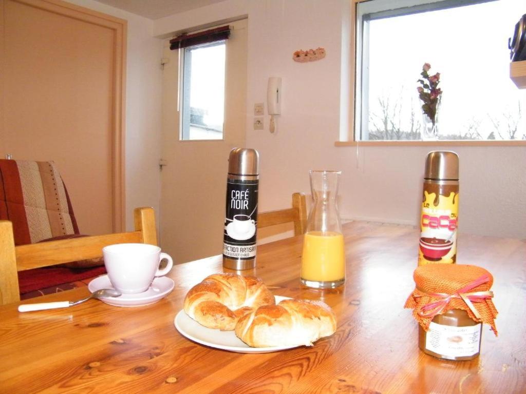 a table with two bottles of orange juice and croissants at Chez Laurent et Sandrine in Chantraine