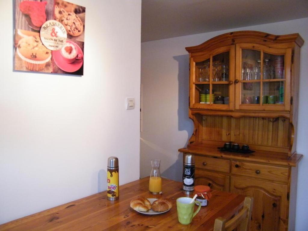 a wooden table in a kitchen with a wooden cabinet at Chez Laurent et Sandrine in Chantraine