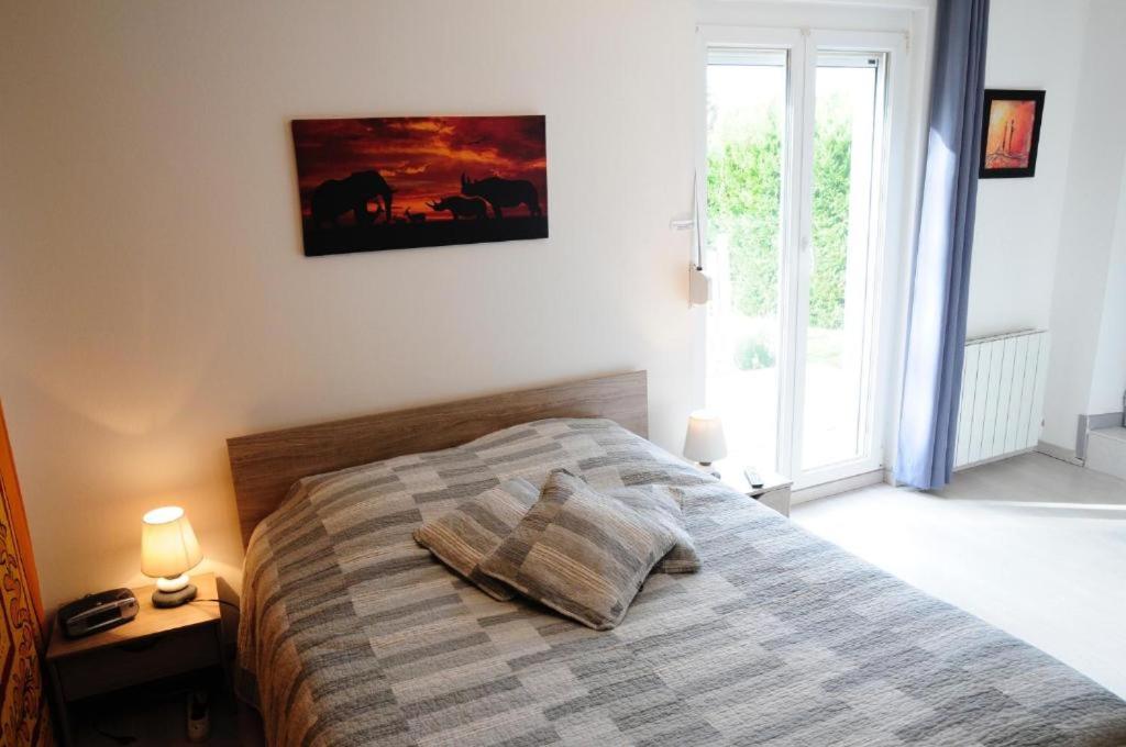 a bedroom with a bed with two pillows on it at Chez Laurent et Sandrine in Chantraine