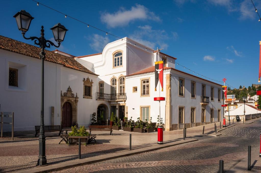 ein weißes Gebäude mit einer Flagge auf einer Straße in der Unterkunft Vila Gale Collection Tomar in Tomar