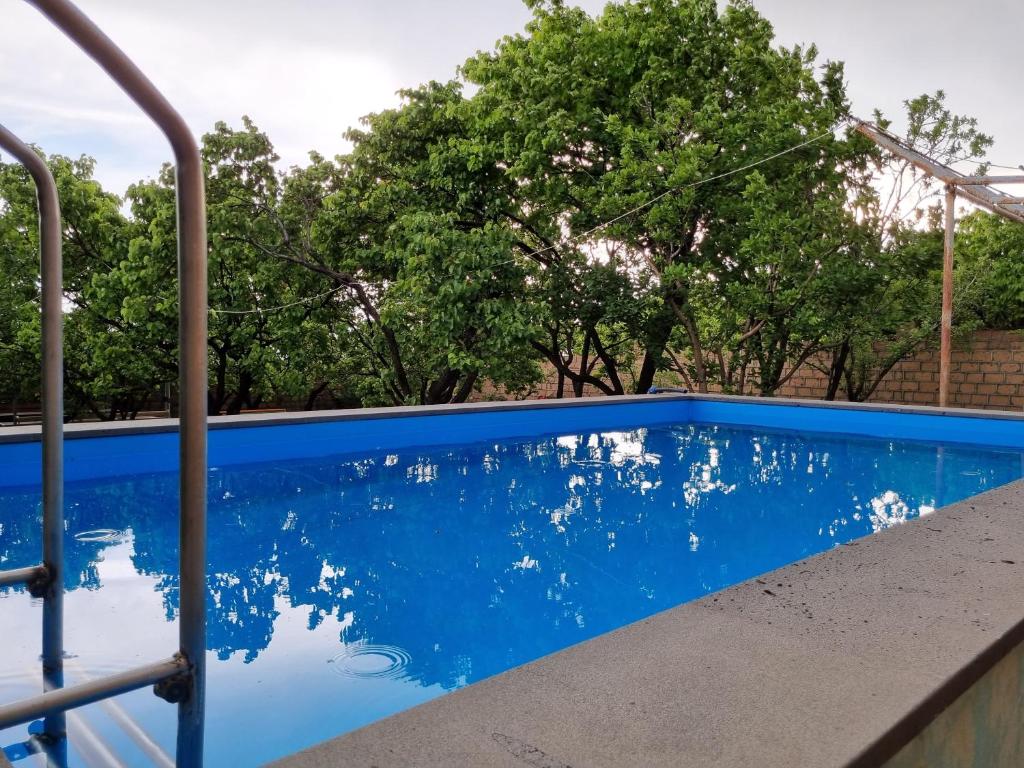 Ashtarak的住宿－Star Apartment Econom in Ashtarak, Mughni，一座绿树成荫的蓝色游泳池
