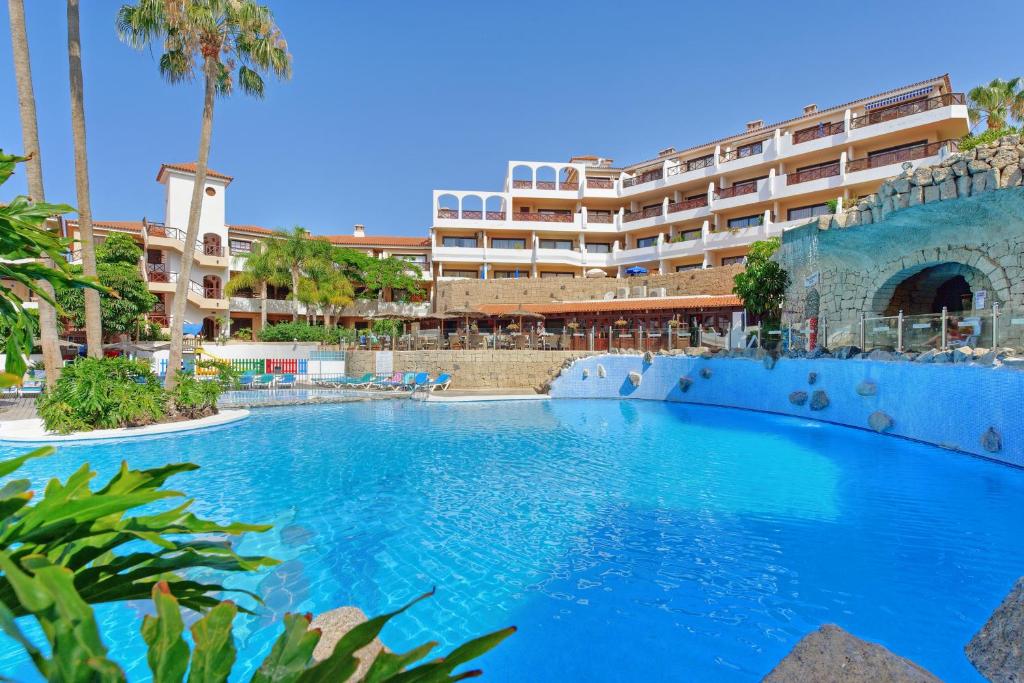 a large swimming pool in front of a hotel at Sunshine Apartments in San Miguel de Abona