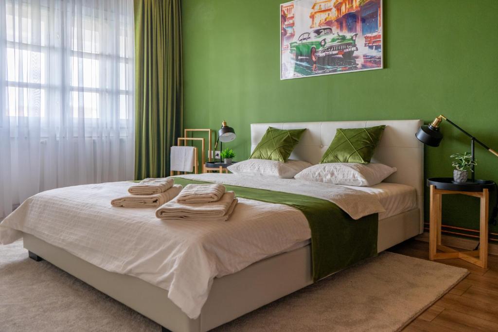 ein Schlafzimmer mit einem großen Bett mit grünen Wänden in der Unterkunft MooToo Central Flat One in Timişoara