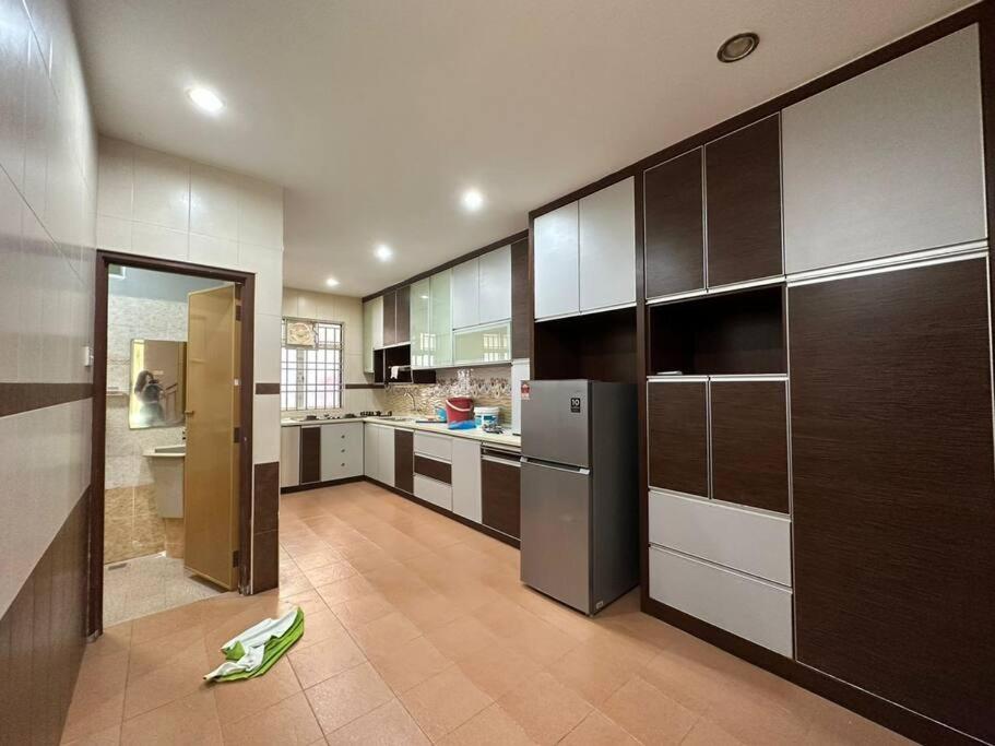 a large kitchen with wooden cabinets and stainless steel appliances at Muslim Suite Home @ Airport Bayan Lepas Penang in Bayan Lepas