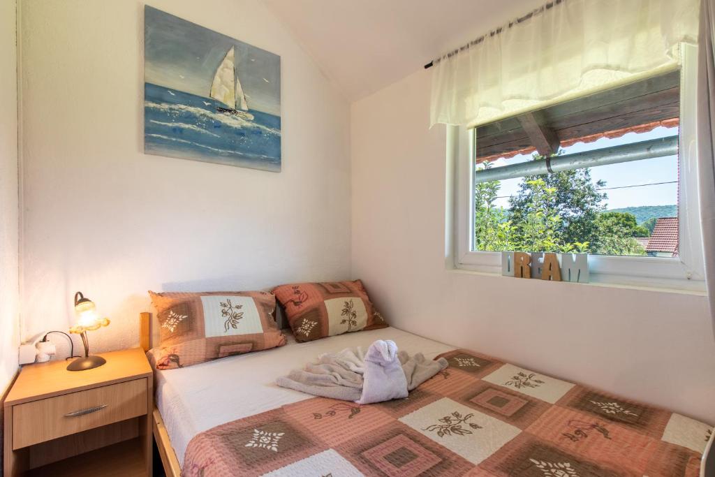 a small bedroom with a bed and a window at Lucija in Lovinac