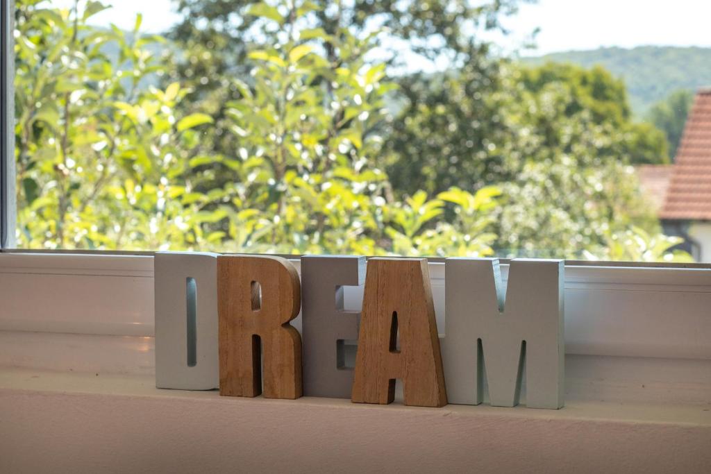 a wooden block with the word home in front of a window at Lucija in Lovinac