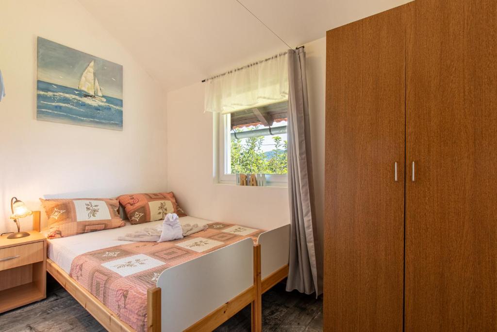 a small bedroom with a bed and a window at Lucija in Lovinac
