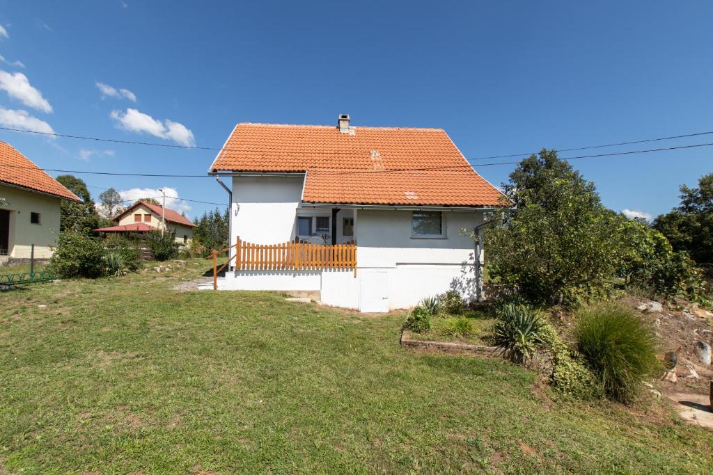 a white house with an orange roof at Lucija in Lovinac