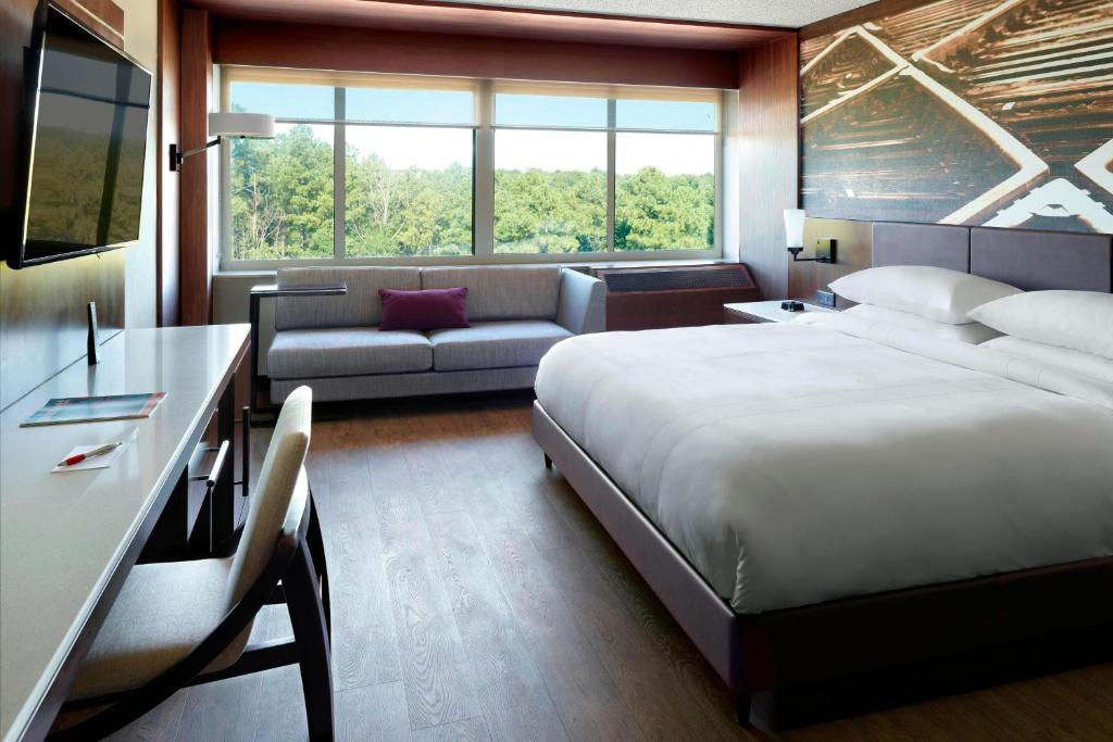 um quarto de hotel com uma cama e um sofá em Atlanta Marriott Peachtree Corners em Norcross