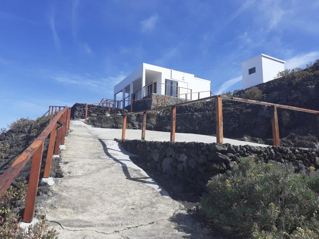 una casa al lado de una colina con una valla en Casa Atlante, en Jedey