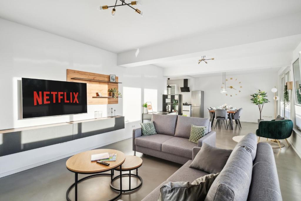 een woonkamer met een bank en een tv bij Design-Apartment - Bochum Zentrum - 2 Balkons - Wanne - 118m2 - Netflix in Bochum