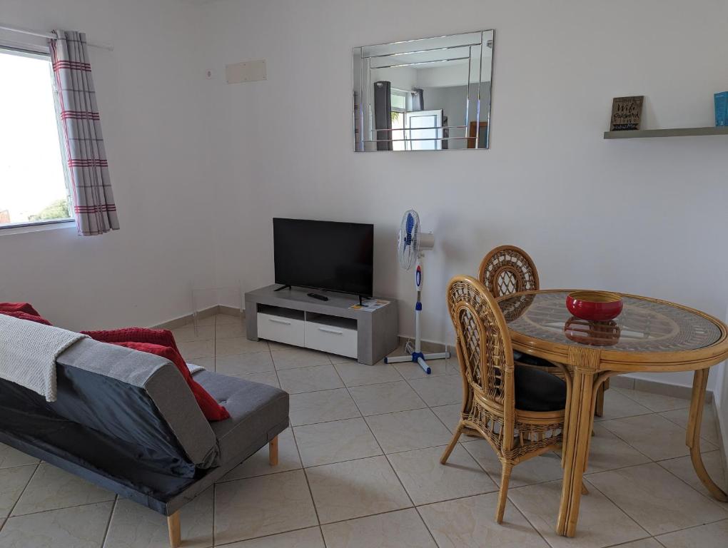 ein Wohnzimmer mit einem Tisch und einem Sofa in der Unterkunft Vila Cabral 1 Bed Apt - Wi-Fi & Air Con Included in Sal Rei