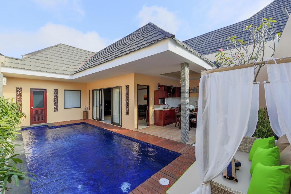 una villa con piscina di fronte a una casa di Flamingo Dewata Pool Villa Uluwatu a Uluwatu