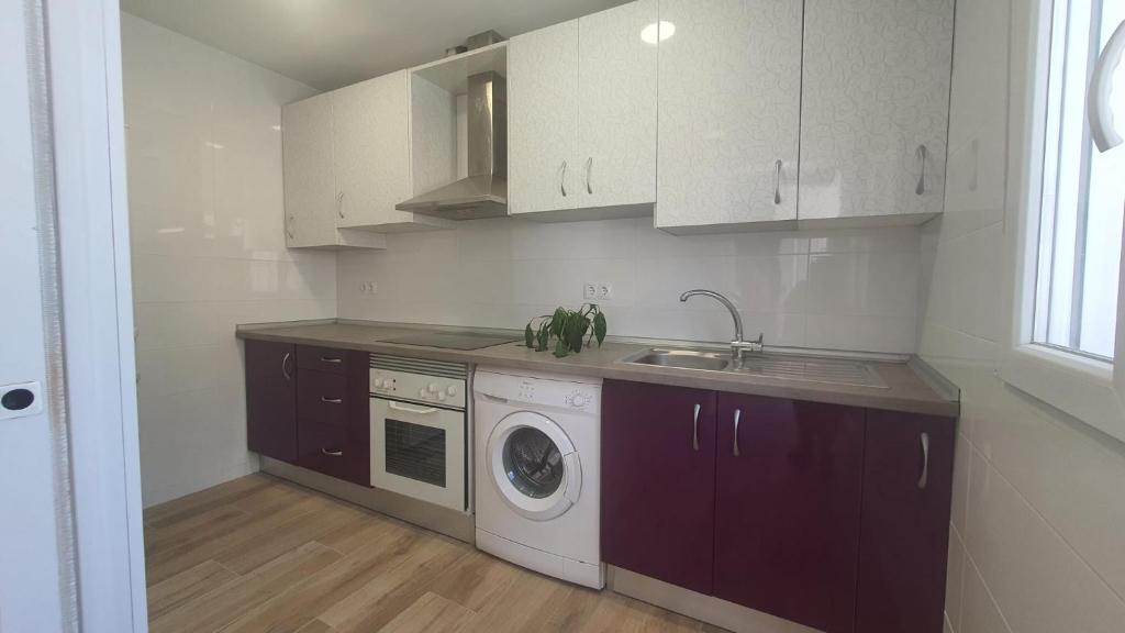 a kitchen with a sink and a washing machine at Casa Nina in Linares