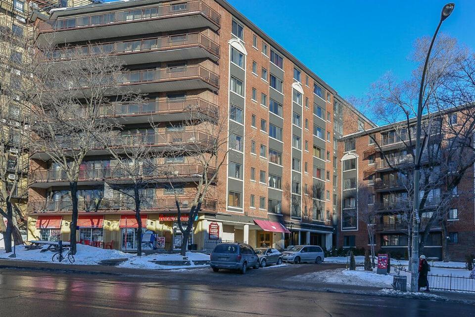 un gran edificio de ladrillo con coches estacionados frente a él en Stylish Montreal Apartment: Comfortable Stay in the Golden Square Mile, en Montreal